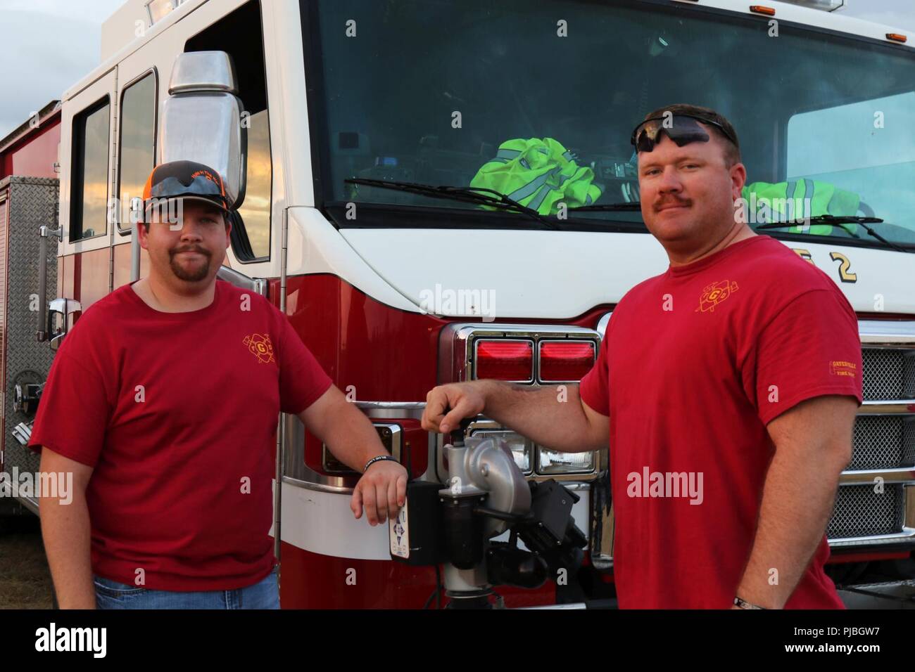 Firefighter Nicholas Brown (Left) and Sgt. 1st Class Michael Bernquist (Right) pose by a fire