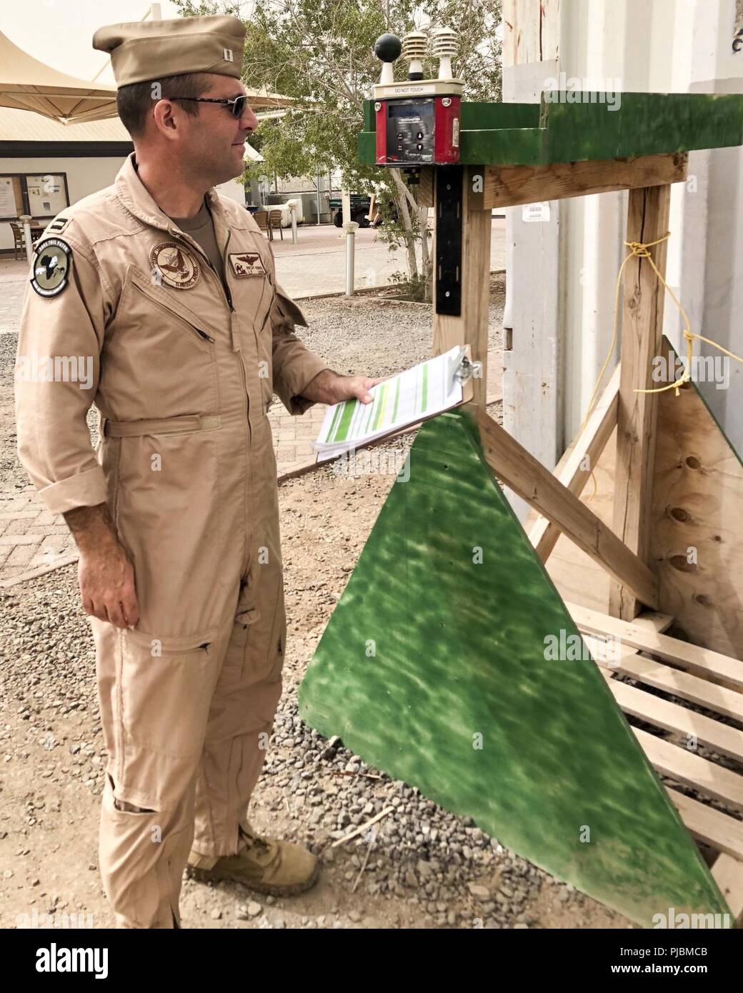 CAMP LEMONNIER, Djibouti – Camp Lemonnier (CLDJ) Safety Officer, Navy Lt. Rich King, inspects the Wet Bulb Globe Temperature (WBGT) device, which is used to measure environmental conditions during physical exercise, June 6, 2018. CLDJ is scheduled to install a second WBGT unit near the turf field on base. Stock Photo