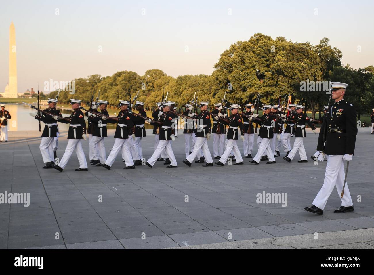 Marines with the U.S. Marine Corps Silent Drill Platoon march across the parade deck during a Tuesday Sunset Parade at the Lincoln Memorial, Washington D.C., July 10, 2018. The guest of honor for the parade was the former Vice President of the U.S., Joe Biden, and the hosting official was the Staff Judge Advocate to the Commandant of the Marine Corps, Maj. Gen. John R. Ewers Jr. Stock Photo