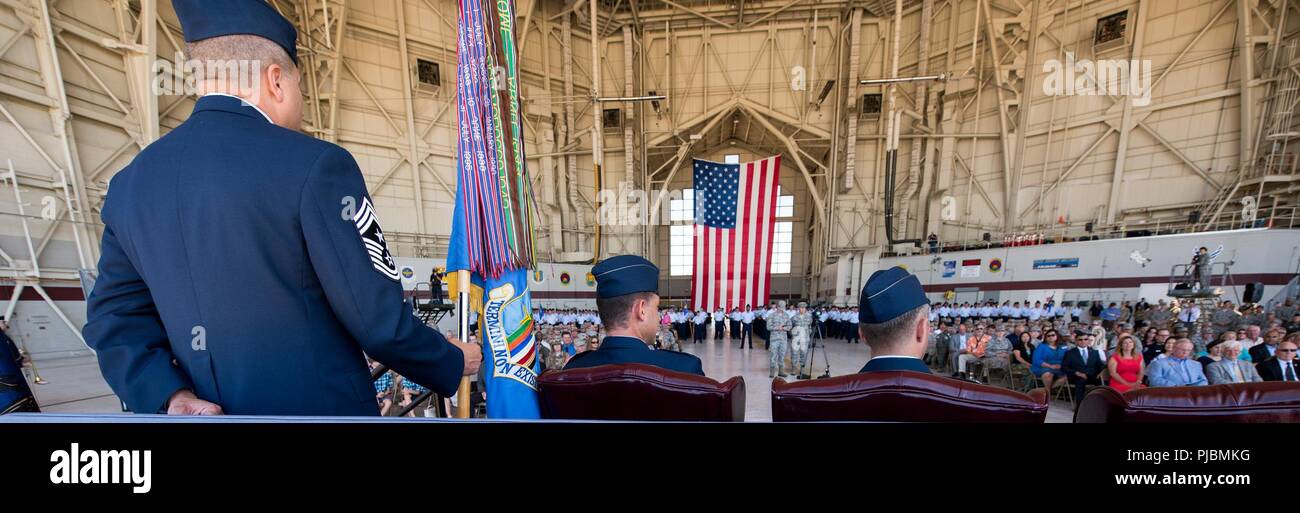 U.S. Air Force Command Chief Master Sgt. Steve Nichols, 60th Air Mobility Wing, secures the guidon during the Change of Command Ceremony at Travis Air Force Base, Calif., July 10, 2018. Col. John Klein relinquished command of Air Mobility Command’s largest wing to Col. Ethan Griffin. Stock Photo