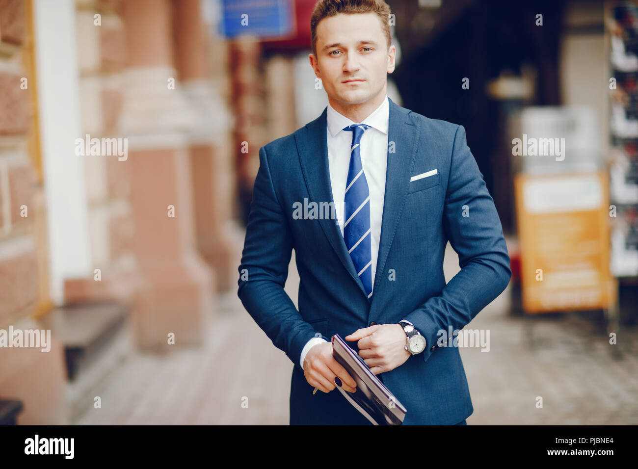 A young and successful man stands in a blue suit Stock Photo - Alamy