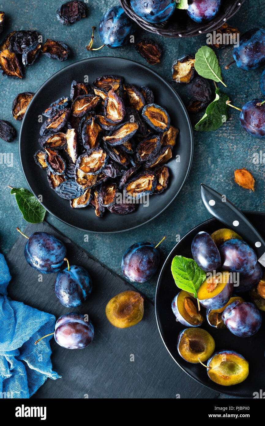 Dried prune and fresh plums with leaves Stock Photo