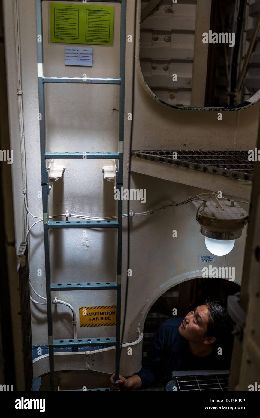 JOINT BASE PEARL HARBOR-HICKAM, Hawaii (July 13, 2018) Gunner's Mate 3rd Class Mandy Nyguien looks up from a ammunitions magazine aboard the guided-missile destroyer USS O'Kane (DDG 77), while conducting an ammunition offload at Joint Base Pearl Harbor-Hickam before getting underway in support of Rim of the Pacific (RIMPAC) exercise, July 13. Twenty-five nations, 46 ships, five submarines, about 200 aircraft and 25,000 personnel are participating in RIMPAC from June 27 to AUG. 2 in and around the Hawaiian Islands and Southern California. The World's largest international maritime exercise, RIM Stock Photo