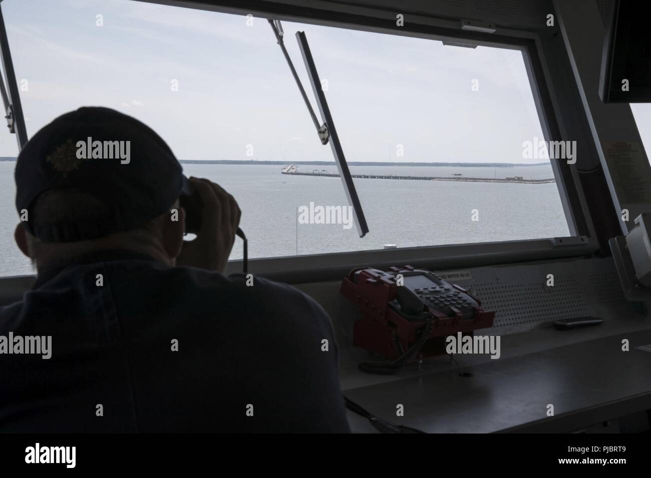 NORFOLK, Va. (July 15, 2018) A Sailor assigned to USS Gerald R. Ford (CVN 78) stands watch on the ship’s bridge as Ford passes the Monitor-Merrimack Bridge Tunnel during sea and anchor detail. Ford departed Norfolk today to begin its Post Shakedown Availability at Huntington Ingalls Newport News Shipbuilding. Stock Photo