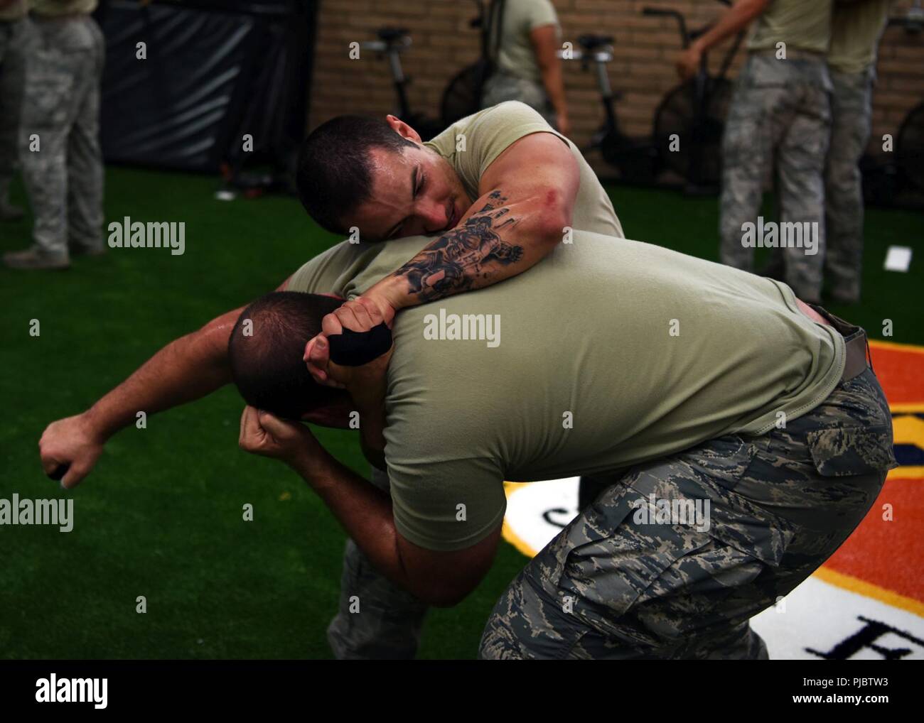 Staff Sgt. Vincent Cavazos, 56th Security Forces Squadron member, practices  a choke defense on Senior Airman Makarios Eshoo, 56th Communications  Squadron Cyber Transport System technician, during training at the Tactical  Integrated Training