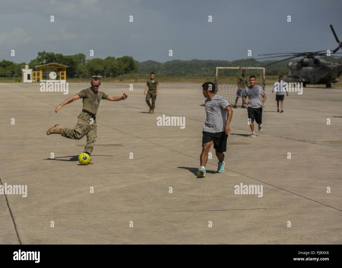 U.S. Marine Staff Sgt. Jesse Braswell, the command element company gunnery sergeant with Special Purpose Marine Air-Ground Task Force - Southern Command, prepares to kick a ball during a friendly game of soccer with the Guatemalan military in Flores, Guatemala, July 4, 2018. The Marines and sailors of SPMAGTF-SC celebrated Independence Day with the Guatemalan military to forge and strengthen bonds between partner nation military forces. The Marines and sailors of SPMAGTF-SC are conducting security cooperation training and engineering projects alongside partner nation military forces in Central Stock Photo