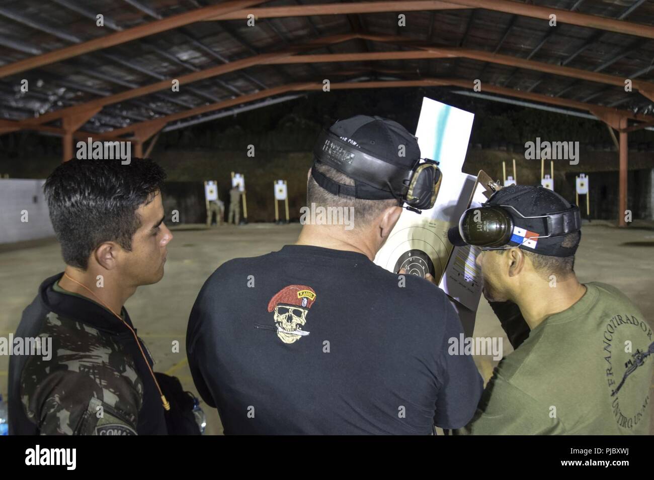 Fuerzas Comando graders check targets after a stress-shoot preceded by by a 20-kilometer ruck march during Fuerzas Comando 18, July 17, 2018 at the Instituto Superior Policial, Panama. Fuerzas Comando is an annual multinational special operational forces skills competition sponsored by U.S. Southern Command and hosted this year by the Ministry of Public Security, Panama. Through friendly competition, this exercise promotes interoperability, military-to-military relationships, increases training knowledge, and improves regional security. Stock Photo