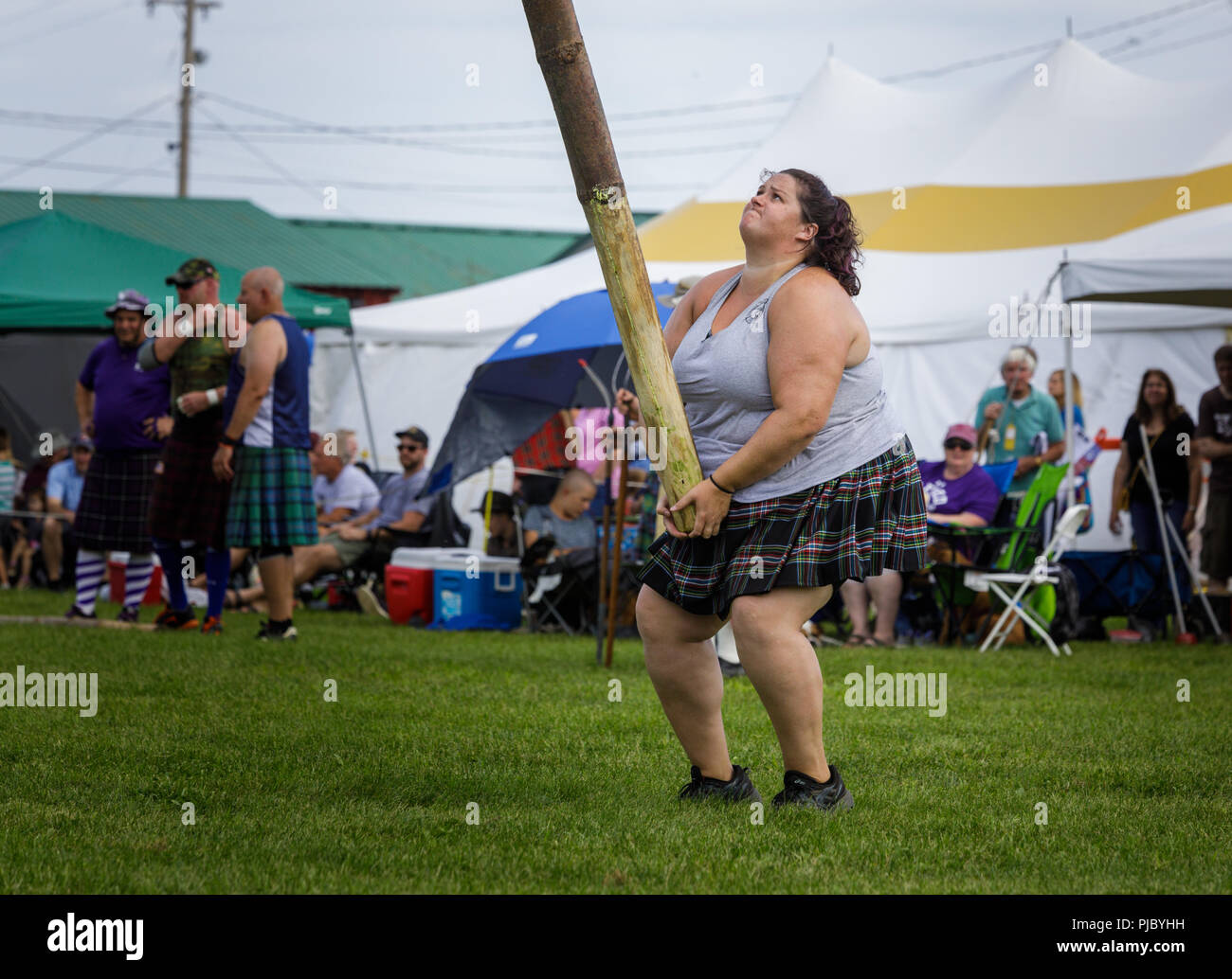 Woman competes in the caber toss at the annual Capital District Scottish Games in Altamont, New York. Stock Photo