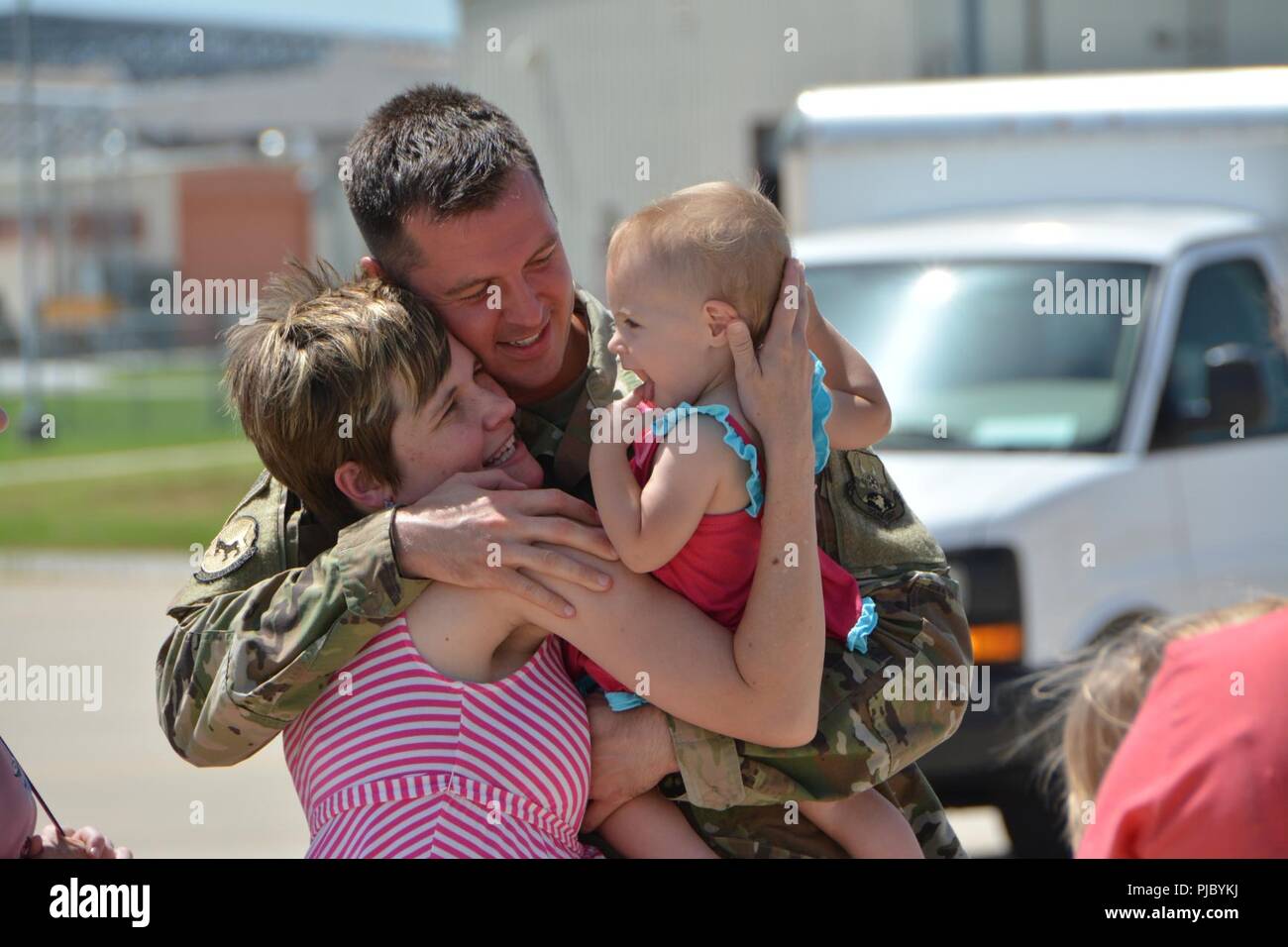 Staff Sgt. Noah Garris, a combat crew communications technician with the 507th Operations Support Squadron at Tinker Air Force Base, Okla., embraces his family following a deployment July 3, 2018. More than 100 Reserve Citizen Airmen from the 507th Air Refueling Wing at Tinker AFB deployed to Incirlik Air Base, Turkey, in support of air operations. Stock Photo