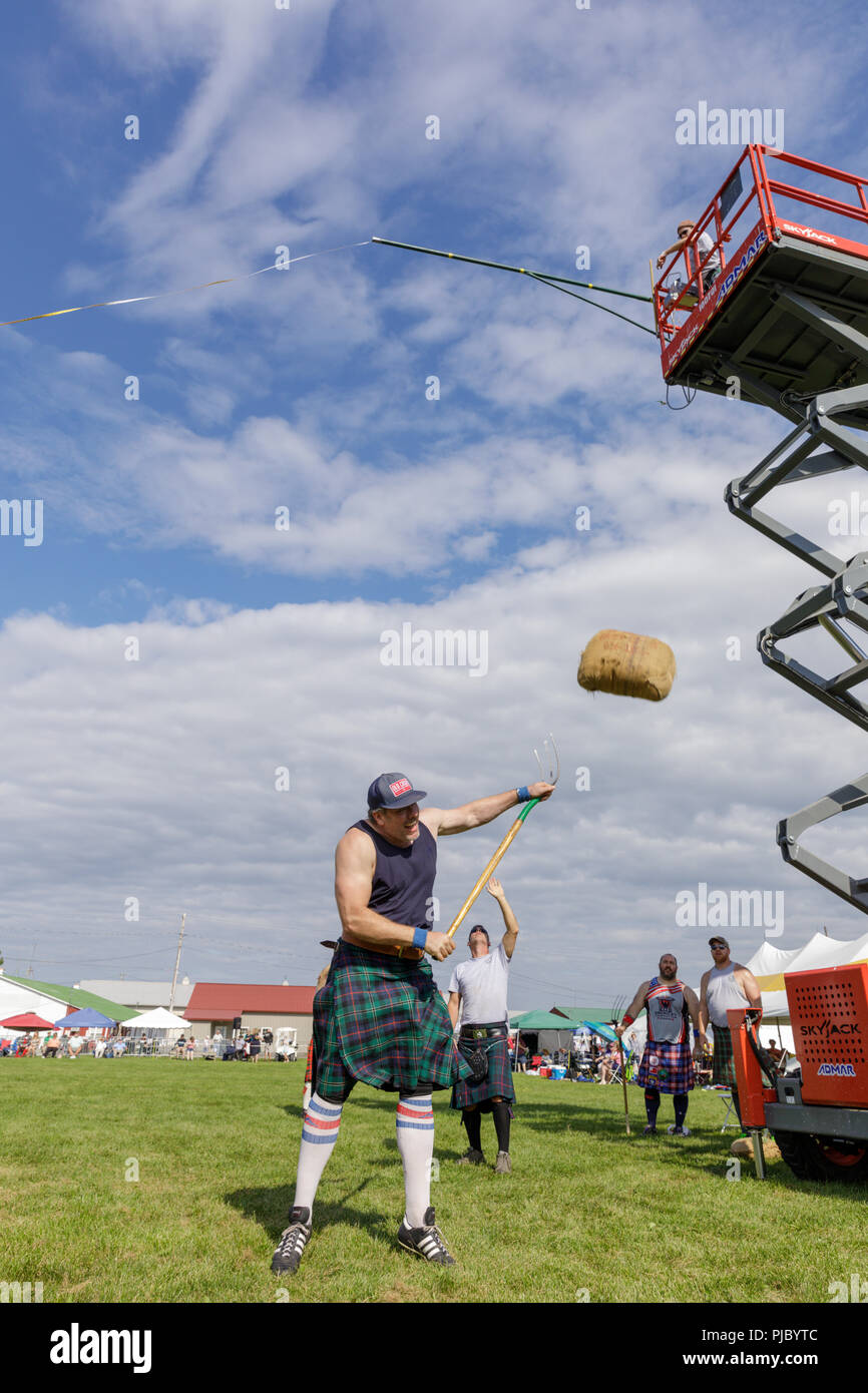 Man competes in the sheaf toss at the annual Capital District Scottish Games in Altamont, New York Stock Photo