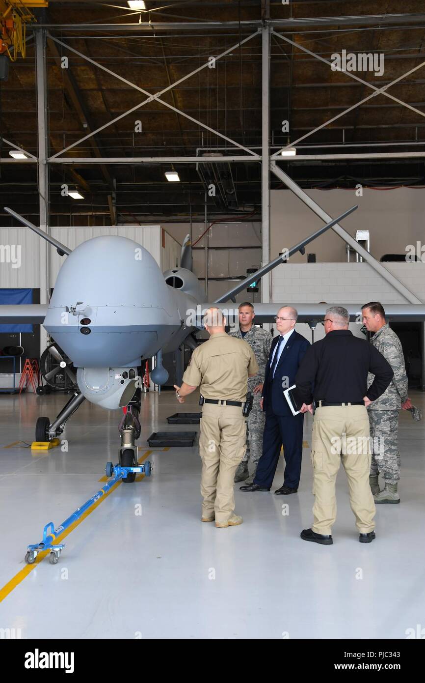 Dominic Pohl, 25th Air Force executive director, center, learns more about the MQ-9 Raptor used by Customs and Border Protection July 20, 2018, on Grand Forks Air Force Base, North Dakota. David Fulcher, CBP director of operations, left, shared with Pohl the specifications of the unmanned aircraft, to include infrared-imaging and long-endurance abilities. Stock Photo