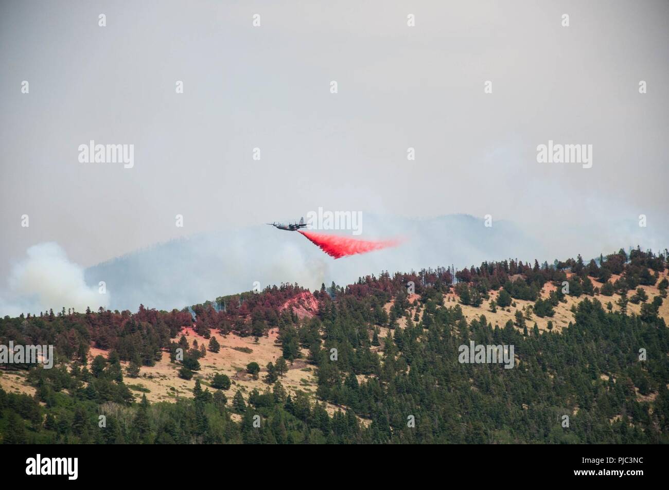 An Air Force C-130 Hercules aircraft, equipped with a Modular Airborne Firefighting System, drops slurry to support fire suppression efforts July 4, 2018. The mission is provided by the Department of Defense at the request of the U.S. Forest Service, which owns the MAFFS equipment and provides the slurry. Stock Photo