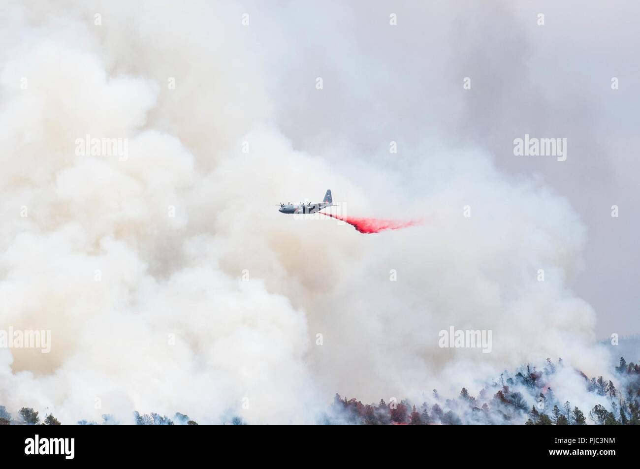 An Air Force C-130 Hercules aircraft, equipped with a Modular Airborne Firefighting System, drops slurry to support fire suppression efforts July 4, 2018. The mission is provided by the Department of Defense at the request of the U.S. Forest Service, which owns the MAFFS equipment and provides the slurry. Stock Photo