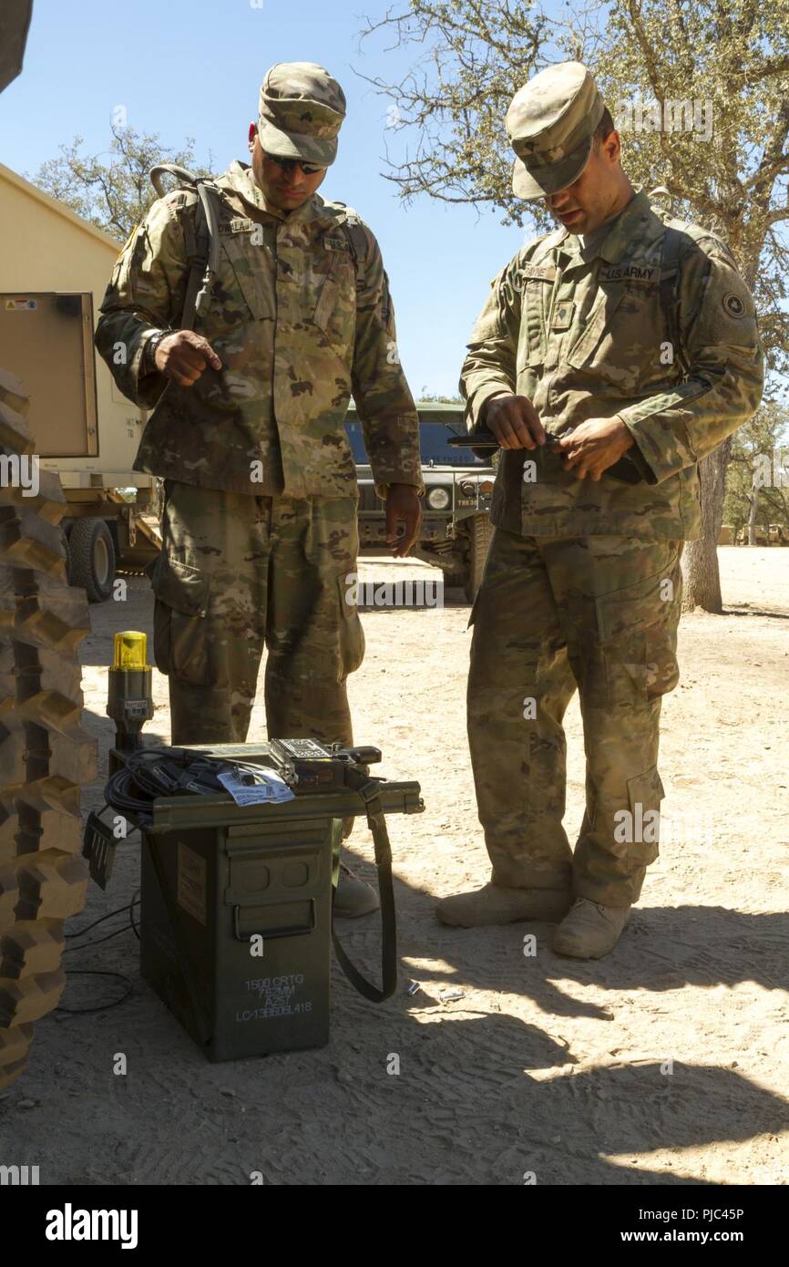 FORT HUNTER LIGGETT-- U.S. Army Sgt. Fakmruddin Dohadwala and Spc. Tyrone Payne of the 348th Transportation Company install a multiple inegrated laser engagement system during the 91st Training Division's Combat Support Training Exercise (CSTX 91-18-01) on July 11, 2018 in Ft. Hunter Liggett, California. The CSTX 91-18-01 ensures America’s Army Reserve units are trained to deploy bringing capable, combat-ready, and lethal firepower in support of the Army and our joint partners anywhere in the world. Stock Photo