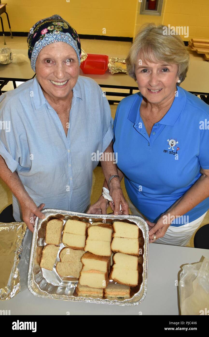 Lyn Pesek, left, and Marie Kaney from the First United Methodist Church of Warrenton Ga., show off their 'famous' pimento cheese sandwiches, a southern delicacy, at Warren County High School July 13, 2018.  Church members provided dinner for the Airmen and Sailors of the East Central Georgia Innovative Readiness Training team as a token of appreciation. IRT servicemembers are providing no-cost medical, dental and optometry services to residents in five area locations. Stock Photo