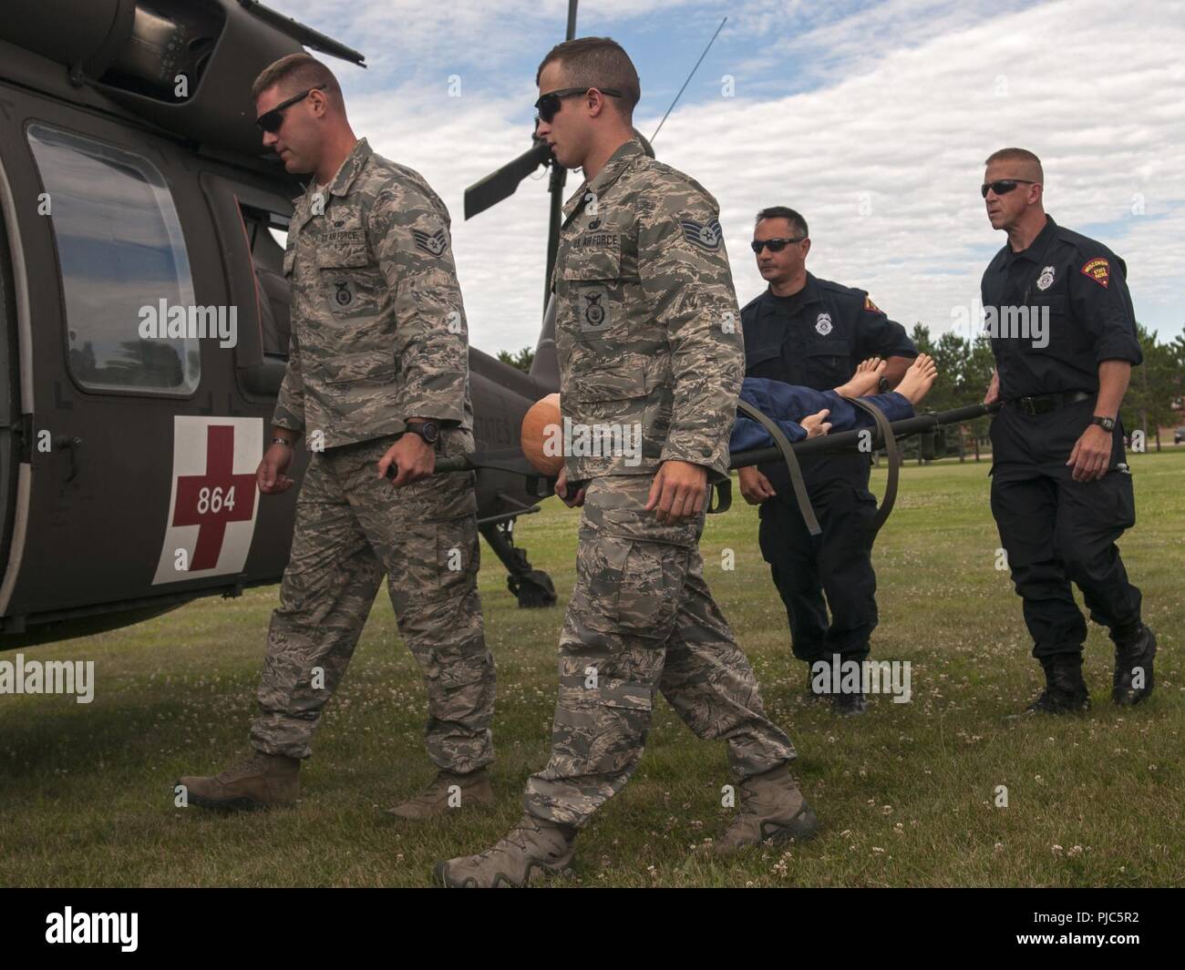 U.S. Air Force Security Forces and Medical Group Airmen from multiple units along with personnel from the Wisconsin State Patrol participated in Medical Evacuation (MEDEVAC) Training with the crew of a Wisconsin Army National Guard UH-60 Blackhawk helicopter during PATRIOT North 18 at Volk Field, Wis., July 16, 2018. PATRIOT is an annual domestic operations training exercise sponsored by the National Guard that focuses on increasing the ability of local, state and federal organizations to coordinate and work together in response to a natural disaster or man-made emergency. Stock Photo