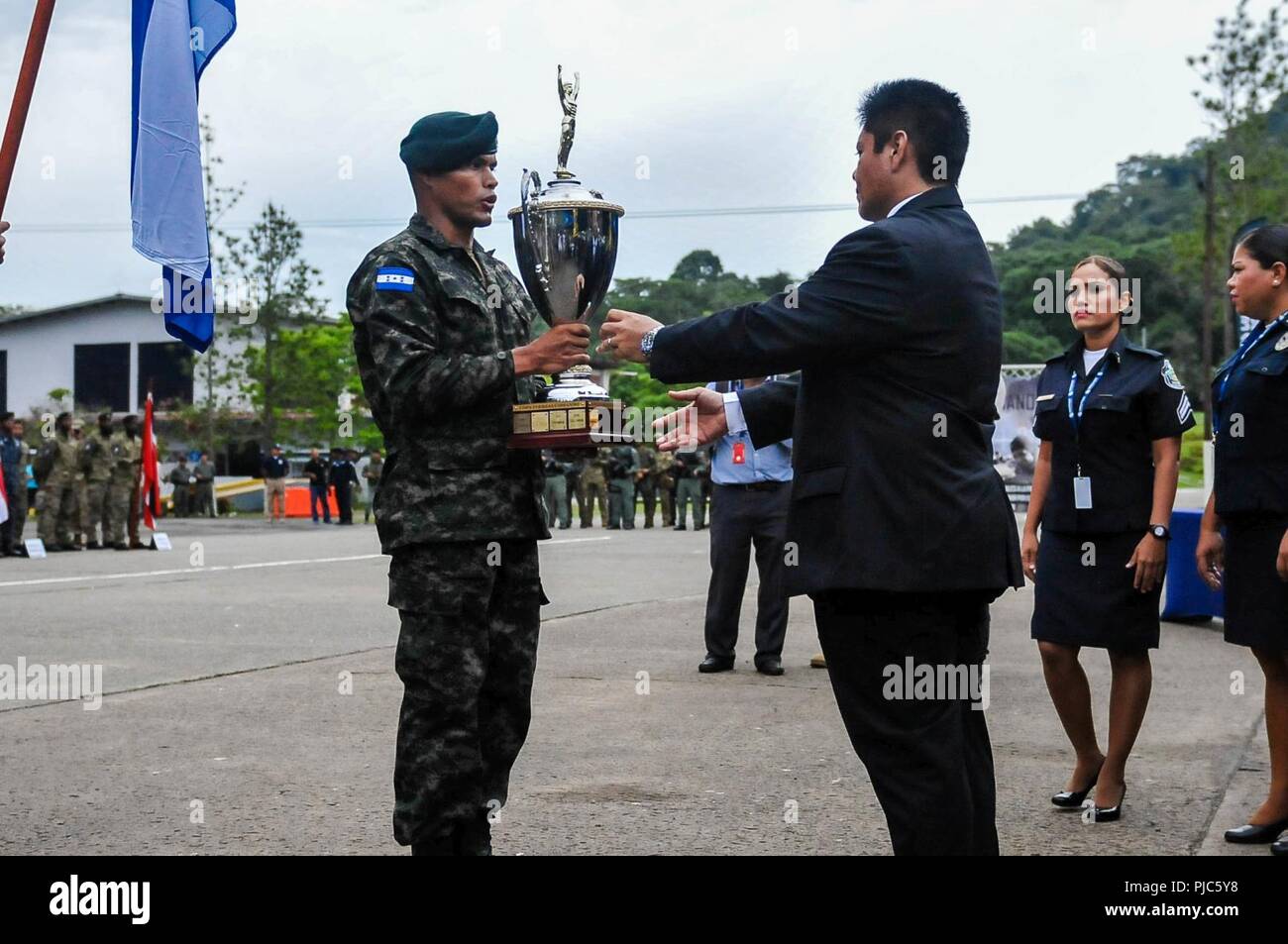 A Honduras Comando passes the Fuerzas Comando trophy to Minister Alexis Bethancourt Yau, minister of public security during the opening ceremony for Fuerzas Comando, July 16, 2018, at the Instituto Superior Policial, Panama. Fuerzas Comando is an annual multinational special operations forces skills competition sponsored by U.S. Southern Command and hosted this year by the Ministry of Public Security, Panama. Through friendly competition, this exercise promotes interoperability, military-to-military relationships, increases training knowledge, and improves regional security. Stock Photo