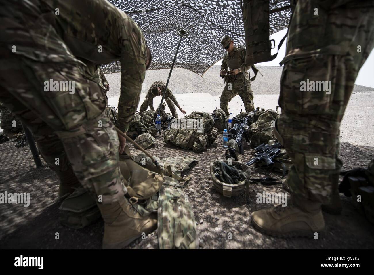 U.S. Army Soldiers, assigned to the 10th Mountain Division and East Africa Response Force, prepare their gear for squad live fire training in Djibouti, July 17, 2018. The EARF quickly and rapidly provides tailorable packages of forces to protect American interests on the African continent should any threats arise. Stock Photo