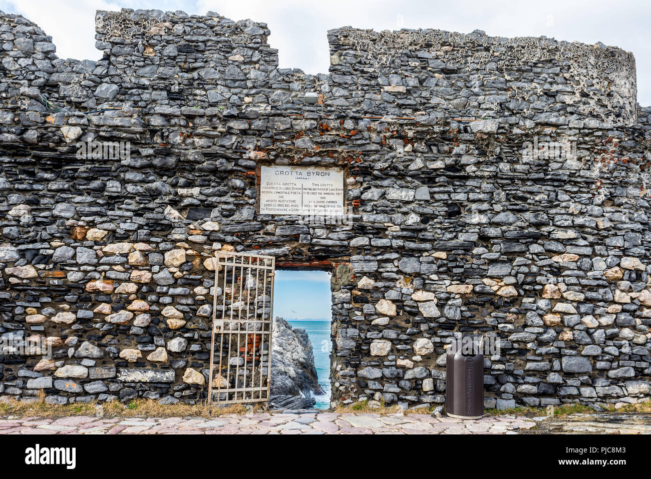 'Lord Byron's Grotto' entrance with gate and commemorative marble plate on an old stone wall belonging to Castle Doria, Portovenere, La Spezia provinc Stock Photo