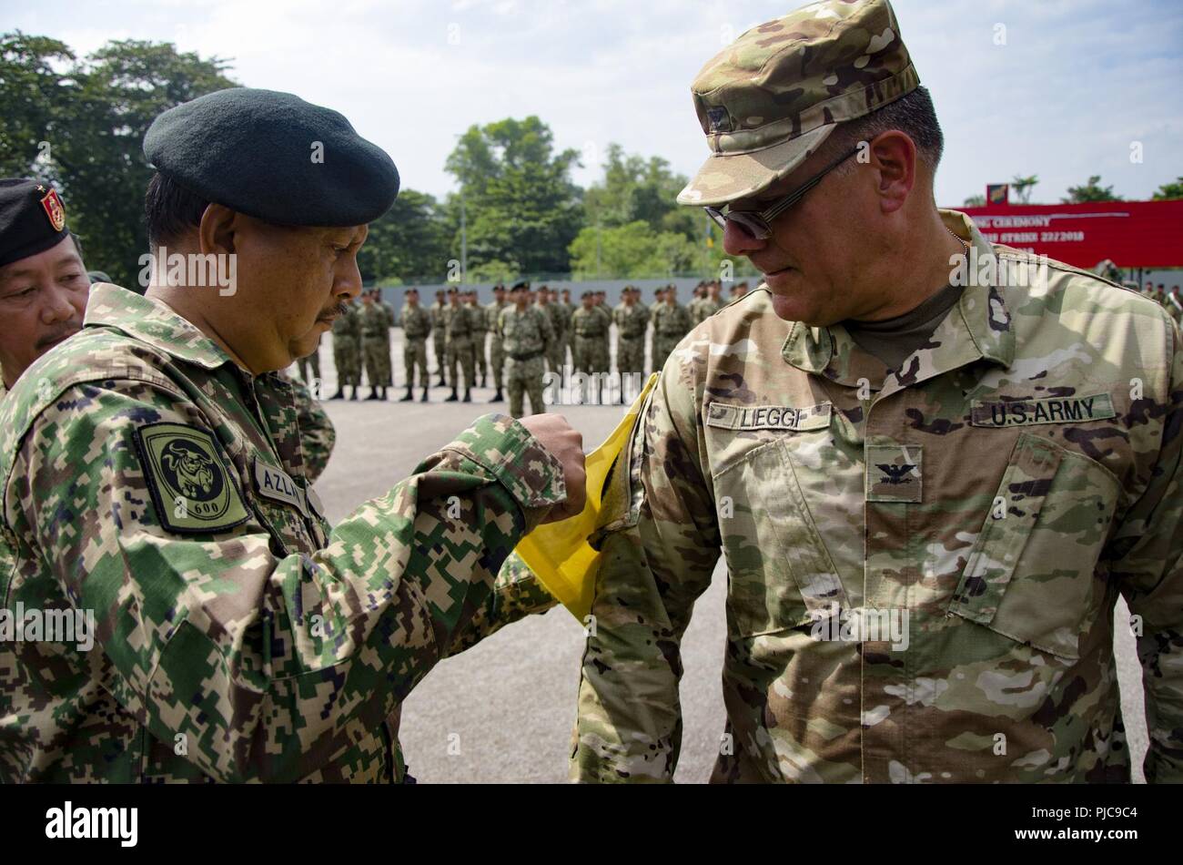 Maj. Gen. Dato HJ Azlan bin Abu Rahman, Chief of Staff, Army Field Command, West Headquarters, Malaysian Army, places a brassard on Col. Anthony Lieggi, Commander, 96th Troop Command, Washington Army National Guard, at the opening ceremony for Exercise Keris Strike, July 23, 2018. Exercise Keris Strike is a bilateral exercise between Malaysia and the U.S., with an emphasis on regional humanitarian assistance and disaster relief operations. Stock Photo