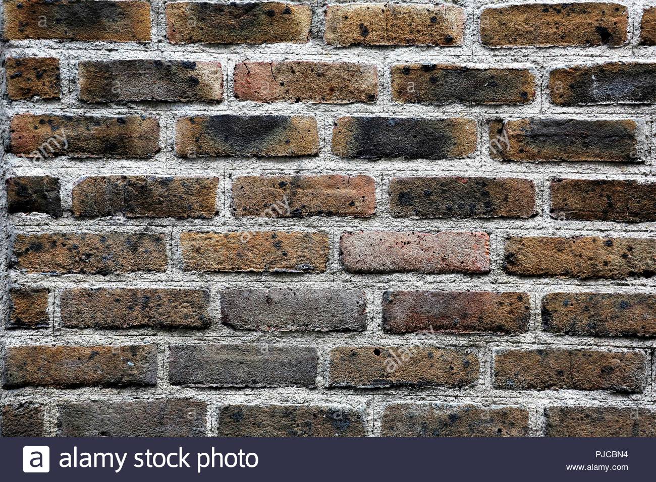 Brickwork in a wall in an urban centre as evening light falls Stock Photo