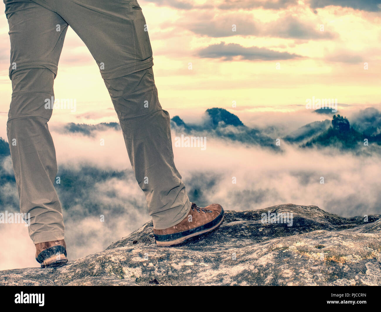 Trekking shoe and legs on rocky hiking trail in mountains motivation inspiration concept. Outdoors achievement, fitness adventure and exercising in wi Stock Photo