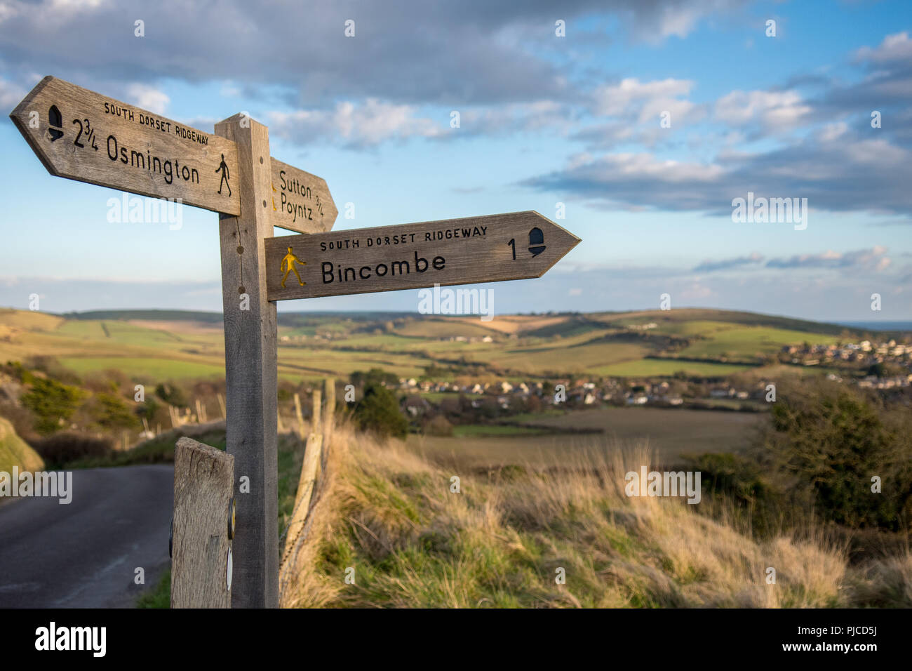Weymouth, England, UK - March 6, 2016: A signpost indicates routes of footpaths including the South Dorset Ridgeway in the rolling landscape of the Do Stock Photo