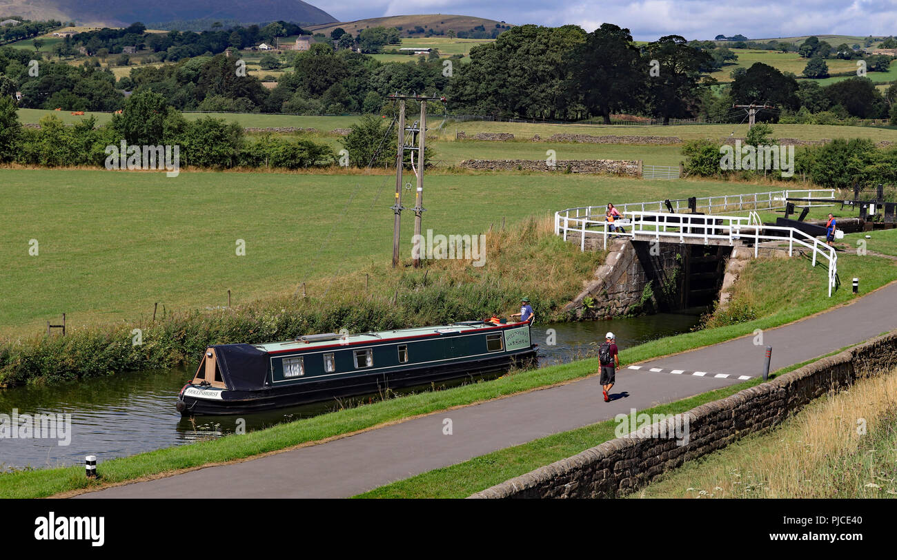 The narrow boat Hollinhurst is descending the Barrowford flight of locks on The Leeds and Liverpool canal in East Lancashire on 30.7.18. Stock Photo
