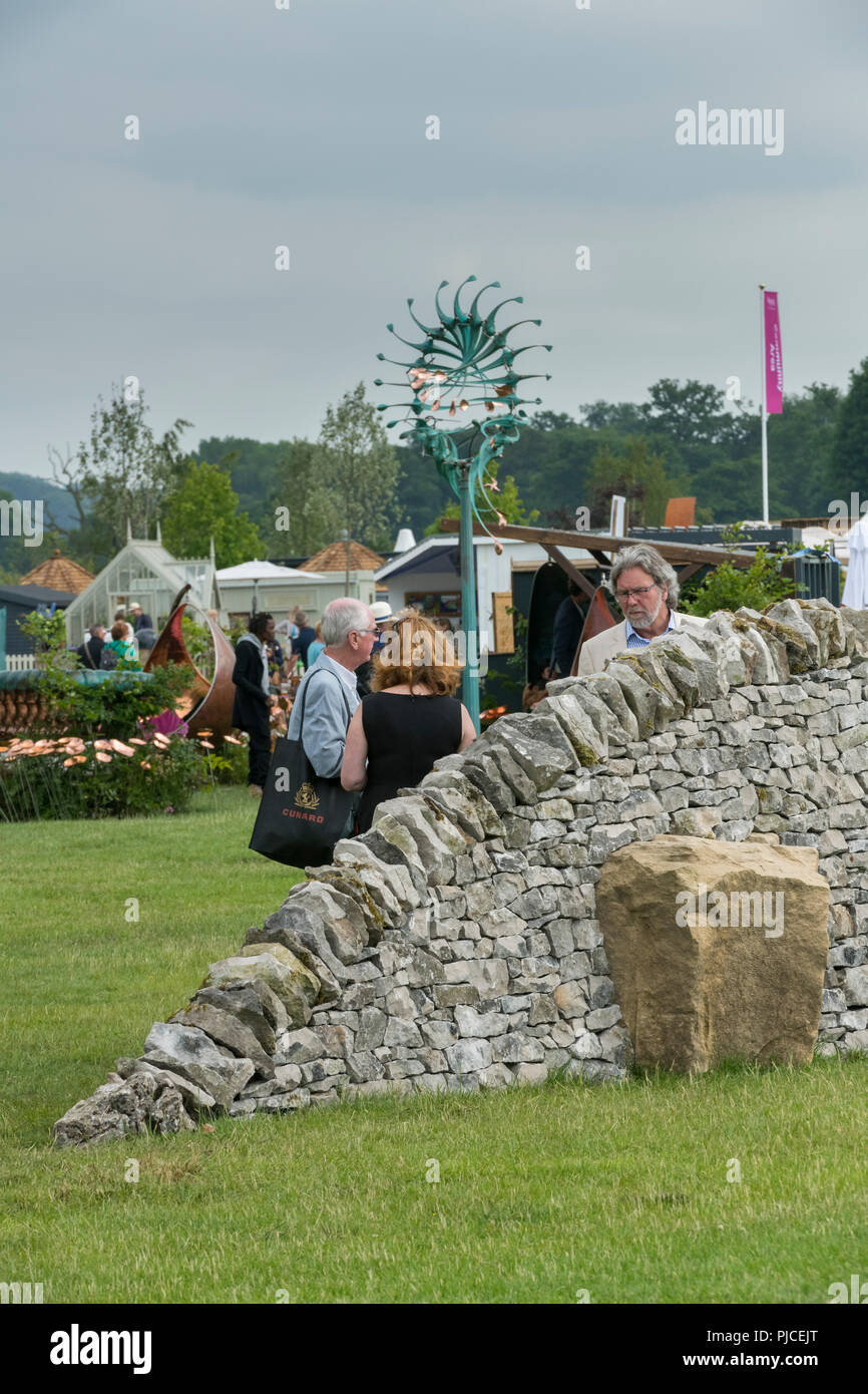 People viewing Wedgewood Emergence, crafted dry stone wall sculptural artwork displayed outside - RHS Chatsworth Flower Show, Derbyshire, England, UK Stock Photo