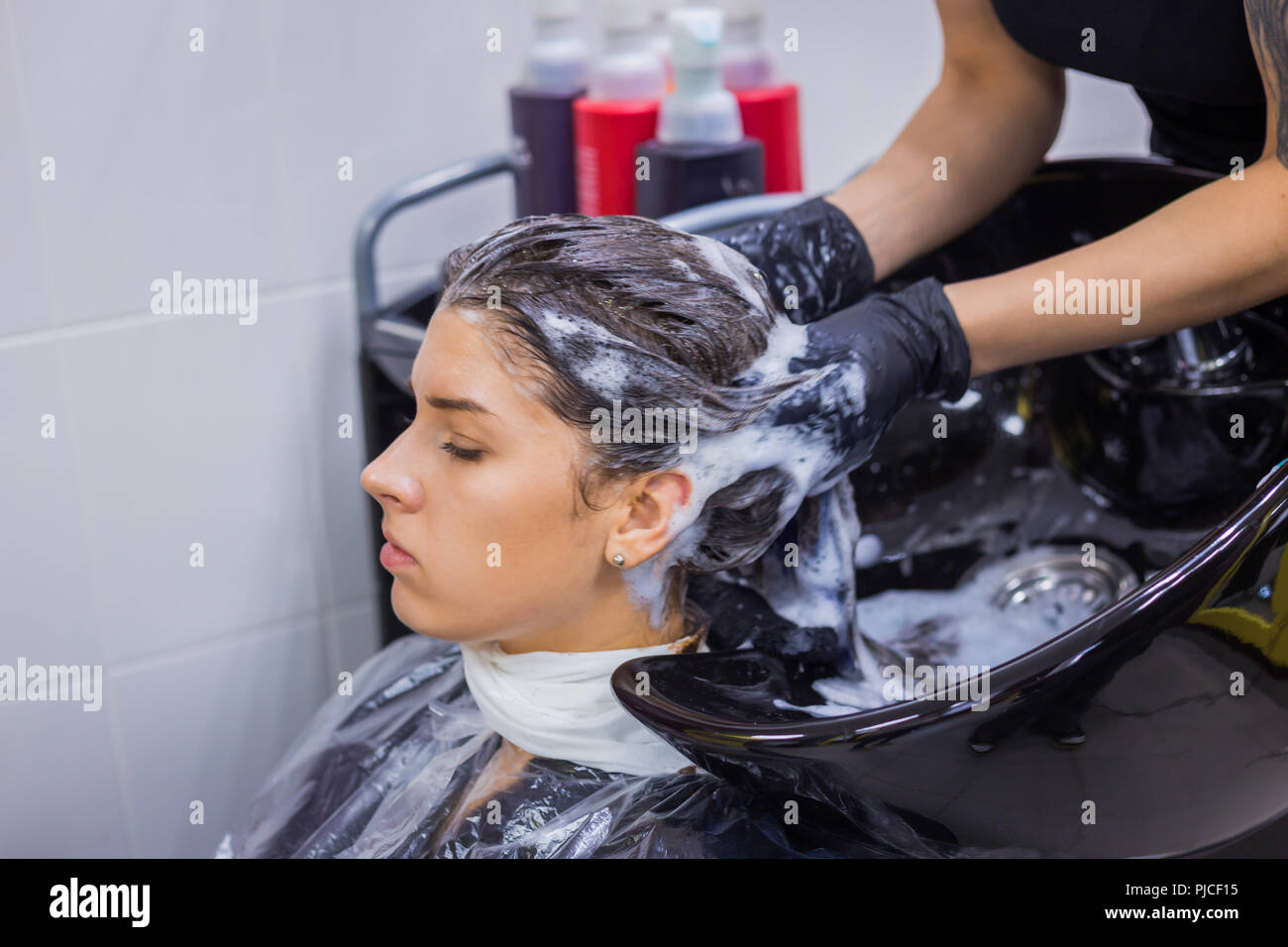 Hairdresser washing hair of woman client Stock Photo