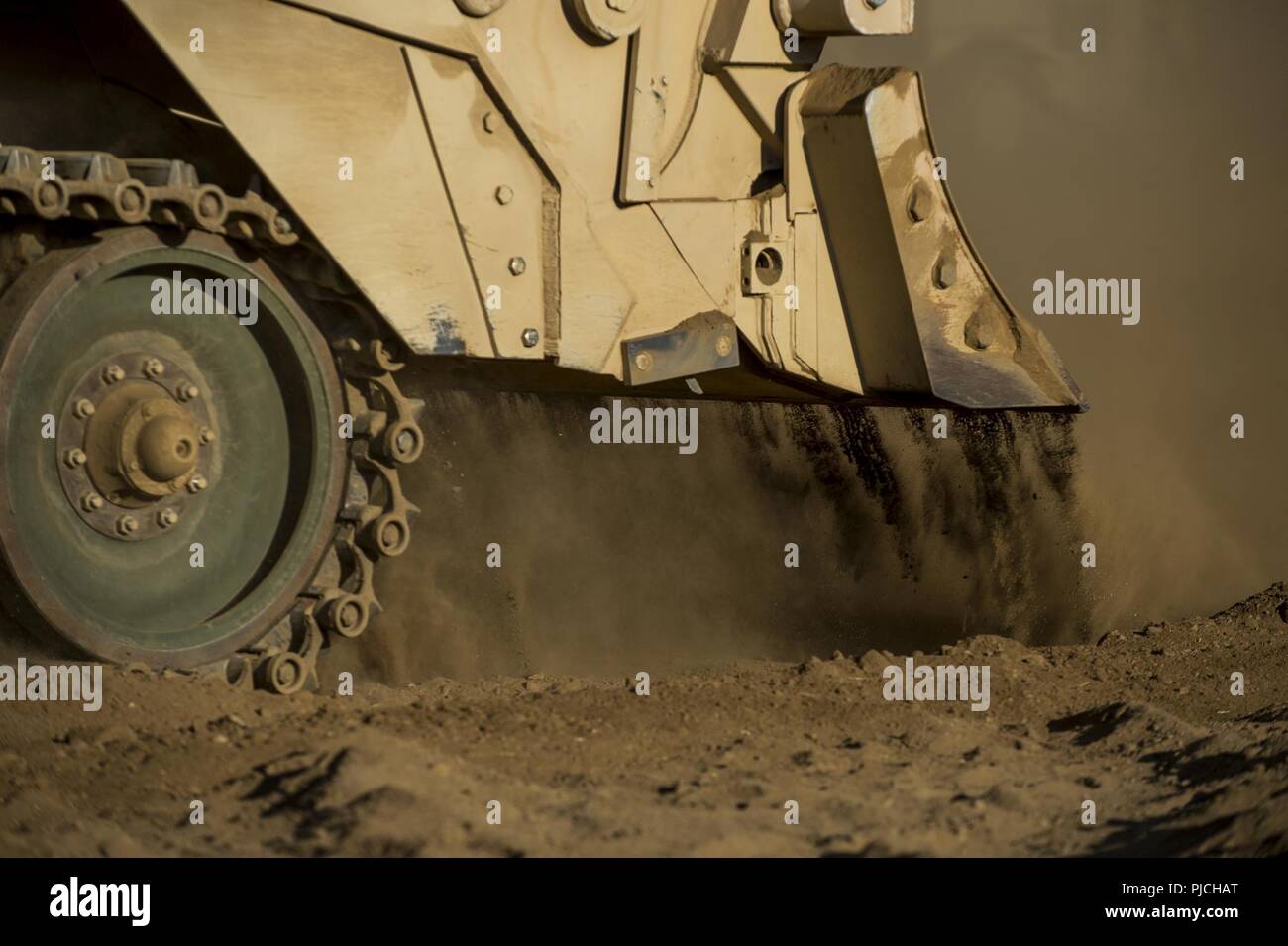 U.S. Army Reserve combat engineer Soldiers use an M9 Armored Combat Earthmover to clear dirt for a combined arms breach during a Combat Support Training Exercise (CSTX) at Fort Hunter Liggett, California, July 22, 2018. This rotation of CSTX runs through the month of July, training thousands of U.S. Army Reserve Soldiers from a variety of functions to include military police, medical, chemical, logistics, transportation and more. Stock Photo