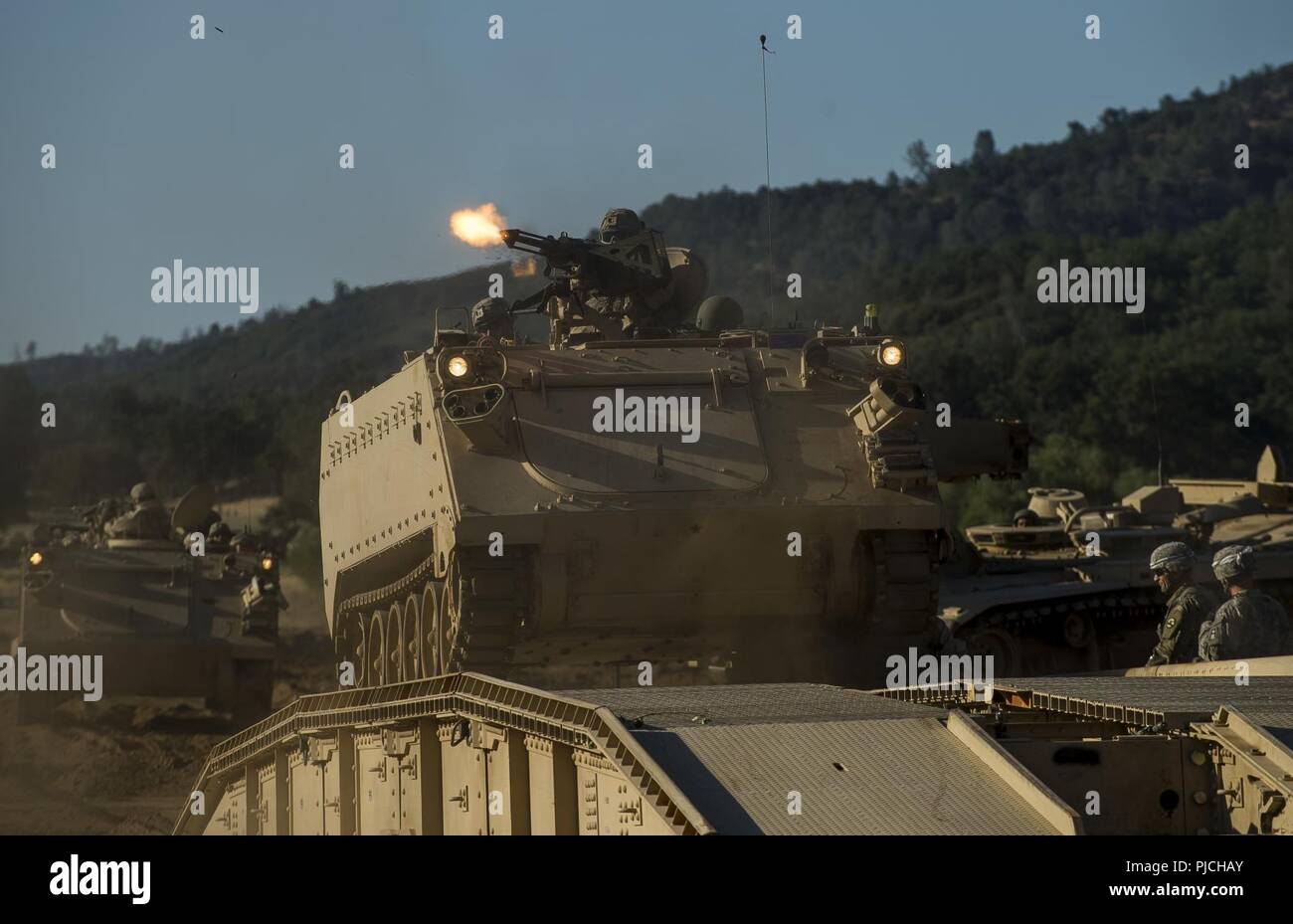 A U.S. Army Reserve combat engineer Soldier from the 350th Engineer Company, of Bell, California, fires an M2 .50-caliber machine gun from an M113 Armored Personnel Carrier on a combined arms breach during a Combat Support Training Exercise (CSTX) at Fort Hunter Liggett, California, July 22, 2018. This rotation of CSTX runs through the month of July, training thousands of U.S. Army Reserve Soldiers from a variety of functions to include military police, medical, chemical, logistics, transportation and more. Stock Photo