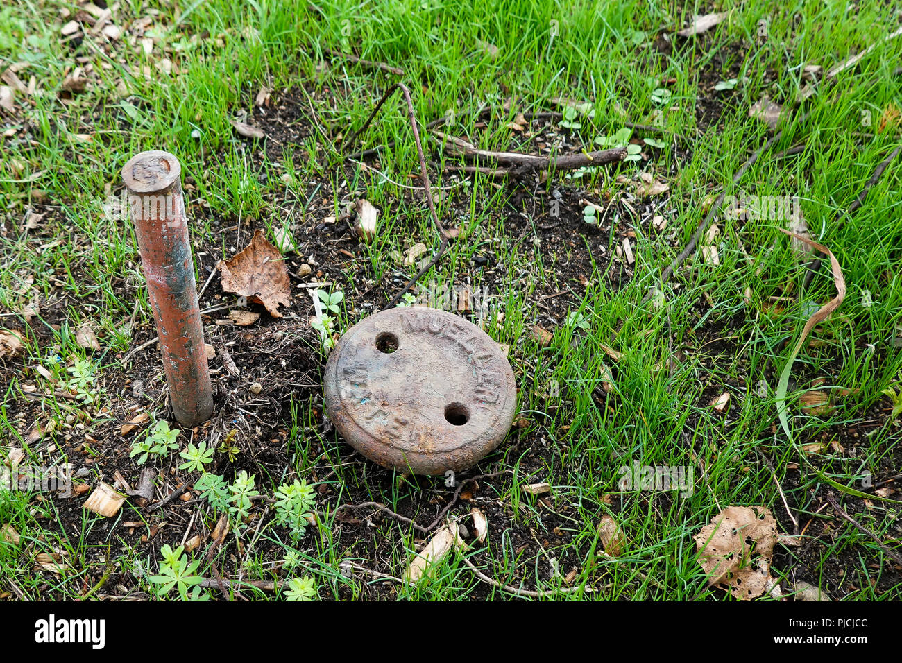 https://c8.alamy.com/comp/PJCJCC/a-rusty-water-shutoff-valve-and-a-survey-stake-marking-a-property-line-with-freshly-planted-grass-PJCJCC.jpg