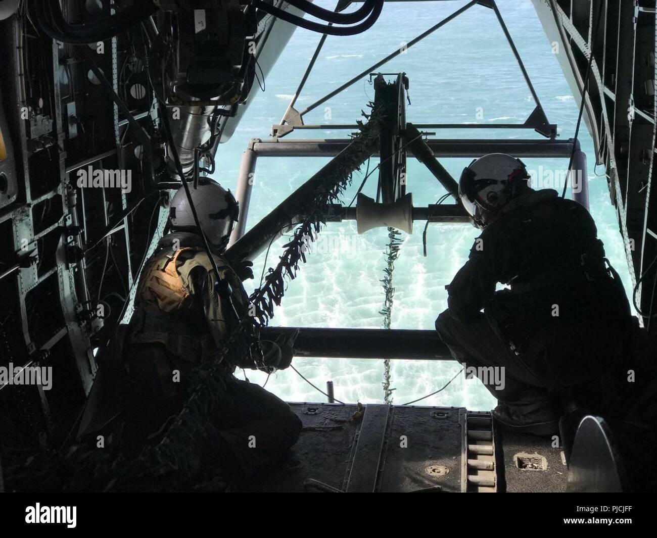 PACIFIC OCEAN (July 24, 2018) Helicopter Mine Countermeasure Squadron Fourteen (HM-14) Naval Aircrewmen (Helicopter) 2nd Class Prickett (left) and McIntyre (right), monitor the towing cable for an AN/AQS-24B Mine Hunting System from an MH-53E Sea Dragon helicopter off the coast of Southern California during a mine hunting exercise as part of Rim of the Pacific (RIMPAC) exercise, July 24. Twenty-five nations, 46 ships, five submarines, about 200 aircraft and 25,000 personnel are participating in RIMPAC from June 27 to Aug. 2 in and around the Hawaiian Islands and Southern California. The world’ Stock Photo