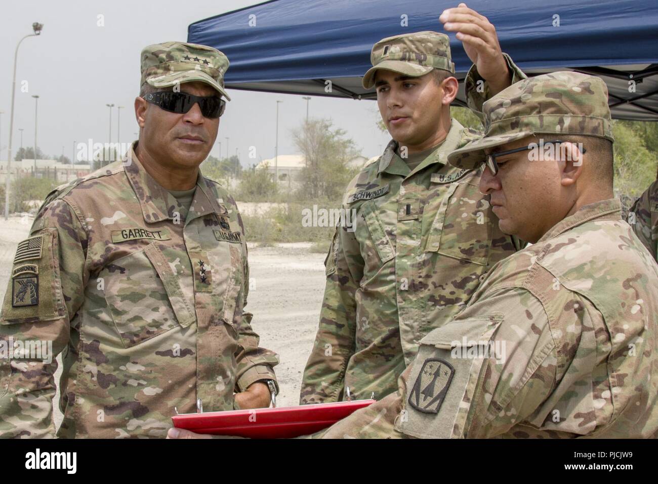 U.S. Army 1st Lt. Jonathan Schwindt, center, with Headquarters and Headquarters Battery, 3rd Battalion, 2nd Air Defense Artillery Regiment, 31st Air Defense Artillery Brigade, briefs U.S. Army Lt. Gen. Michael X. Garrett, U.S. Army Central (USARCENT) commanding general, prior to a visit, July 22, 2018. Lt. Gen. Garrett visited the battalion as part of his battlefield circulation, which enhances his understanding of the units and Soldiers subordinate to USARCENT. Stock Photo