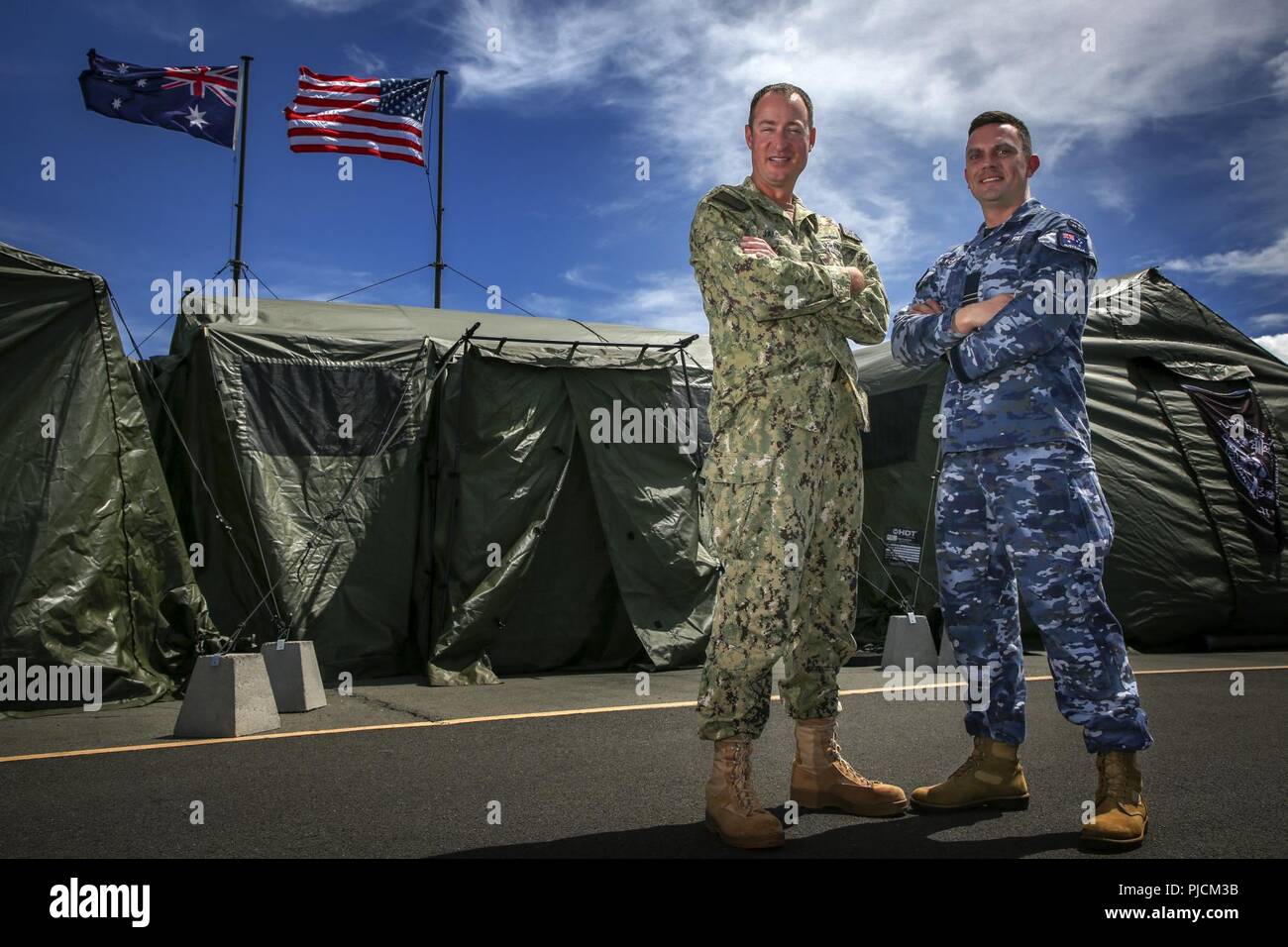 JOINT BASE PEARL HARBOR-HICKAM, Hawaii (July 21, 2018) Combined Task Group Operations Director, U.S. Navy Lt. Commander Tres James, and Combined Task Group Battle Watch Captain, Royal Australian Air Force Flight Lieutenant David Reid, stand outside the combined watch floor and mobile tactical operations center during Rim of the Pacific (RIMPAC) exercise, July 21. Twenty-five nations, 46 ships, five submarines, and about 200 aircraft and 25,000 personnel are participating in RIMPAC from June 27 to Aug. 2 in and around the Hawaiian Islands and Southern California. The world’s largest internation Stock Photo