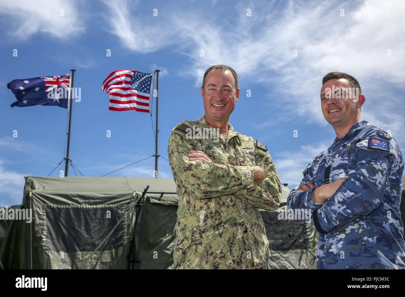 JOINT BASE PEARL HARBOR-HICKAM, Hawaii (July 21, 2018) U.S. Navy Lt. Cmdr. Tres James, combined task group operations director, and Royal Australian Air Force Flight Lieutenant David Reid, combined task group battle watch captain, stand outside the combined watch floor and mobile tactical operations center during Rim of the Pacific (RIMPAC) exercise, July 21. Twenty-five nations, 46 ships, five submarines, and about 200 aircraft and 25,000 personnel are participating in RIMPAC from June 27 to Aug. 2 in and around the Hawaiian Islands and Southern California. The world’s largest international m Stock Photo
