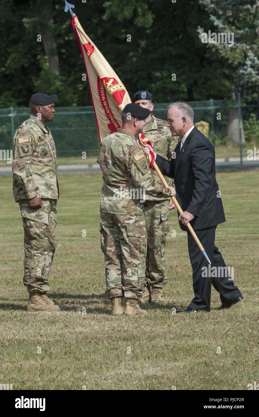 Ansbach, Germany -- Mr. Michael D. Formica, Installation Management Command Europe Region director passes the unit colors to incoming United States Army Garrison (USAG) Ansbach commander Col. Steven M. Pierce, signifying Pierce’s acceptance of command over garrison operations and security during the USAG Ansbach Change of Command ceremony at Barton Barracks parade field, Ansbach, Germany, July 18, 2018 Stock Photo