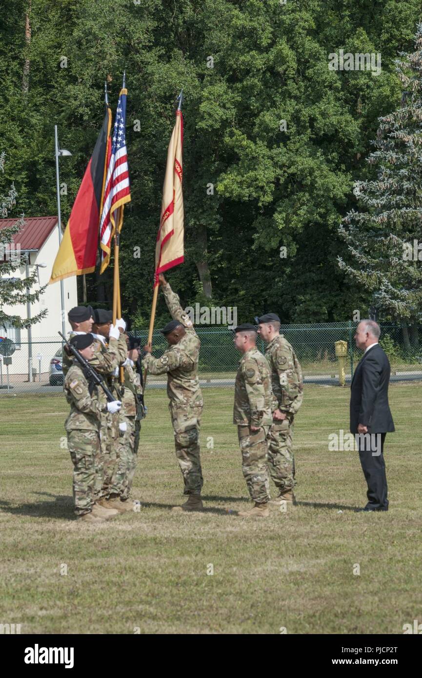 Ansbach, Germany -- U.S. Army Garrison (USAG) Ansbach Command Sgt. Maj. Philson Tavernier returns the colors to the guard during the USAG Ansbach Change of Command ceremony at Barton Barracks parade field, Ansbach, Germany, July 18, 2018. During the ceremony outgoing commander Col. Benjamin C. Jones (second from right) relinquished command to incoming commander Col. Steven M. Pierce (center right). Stock Photo