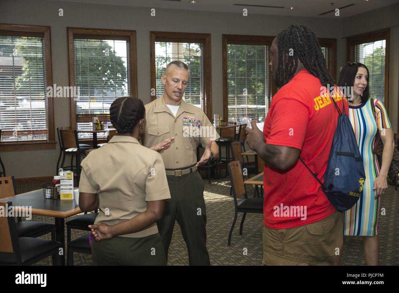 U.S. Marine Corps Maj. Villiana Jean Francois, supply officer, 4th Marine Logistics Group, and Ricky Jean Francois, a defensive tackle football player in the National Football League, speaks to Col. William C. Bentley III, base commanding officer of Marine Corps Base Quantico (MCBQ), during breakfast at the Medal of Honor Golf Course on MCBQ, Va., July 20, 2018. Maj. Jean Francois was touring the base with her brother Ricky Jean Francois, a defensive tackle football player in the National Football League, to promote the Manpower & Reserve Affairs Behavioral Health and Suicide Prevention Progra Stock Photo