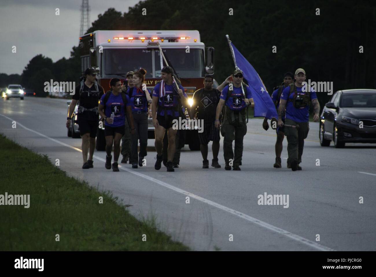 Family and friends of the seven U.S. Marine Raiders and nine Marine Aviator crew members who died in the July, 2017, KC-130 crash in Laflore County, Miss., hike on the shoulder of US-17 in Jacksonville, N.C., during a 900-mile memorial hike from Itta Bena, Miss., to Stump Sound Park, Sneads Ferry, N.C., July 24. 10 teams took turns hiking a continuous 24 hours until reaching Stump Sound Park, but the final stretch finished at the MARSOC Compound on MCB Camp Lejeune. Stock Photo
