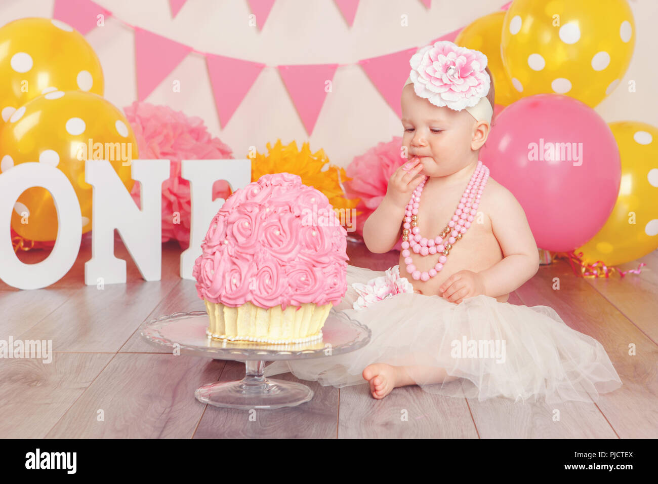 Portrait of cute adorable Caucasian baby girl in tutu tulle skirt  celebrating her first birthday. Cake smash concept. Child kid sitting on  floor in st Stock Photo - Alamy