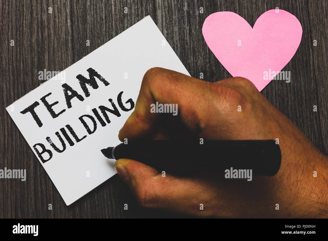 Handwriting text writing Team Building. Concept meaning Types of activities  used to enhance social relations Man hand holding marker white paper roman  Stock Photo - Alamy