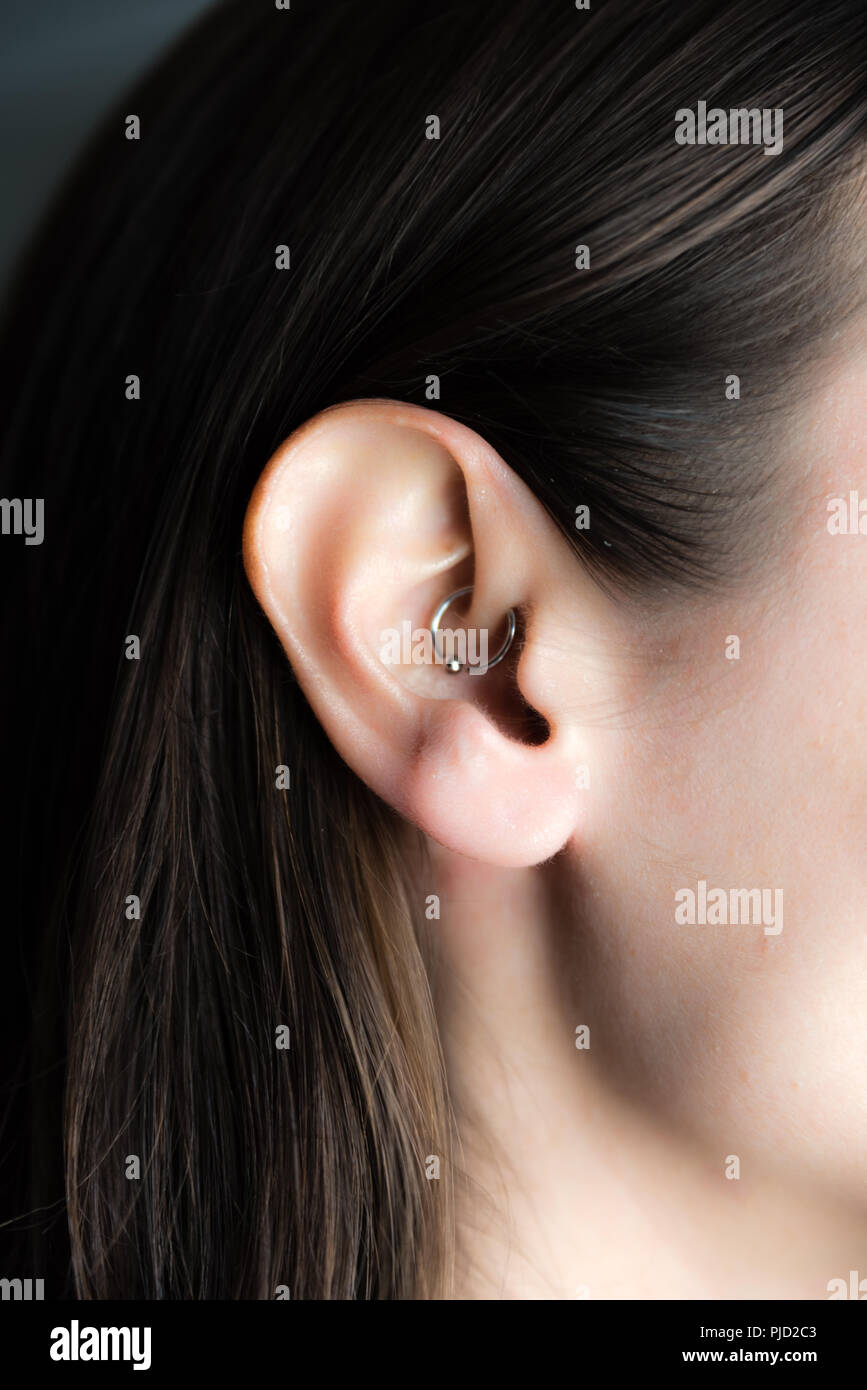 medicinal earring in ear to treat headaches Stock Photo