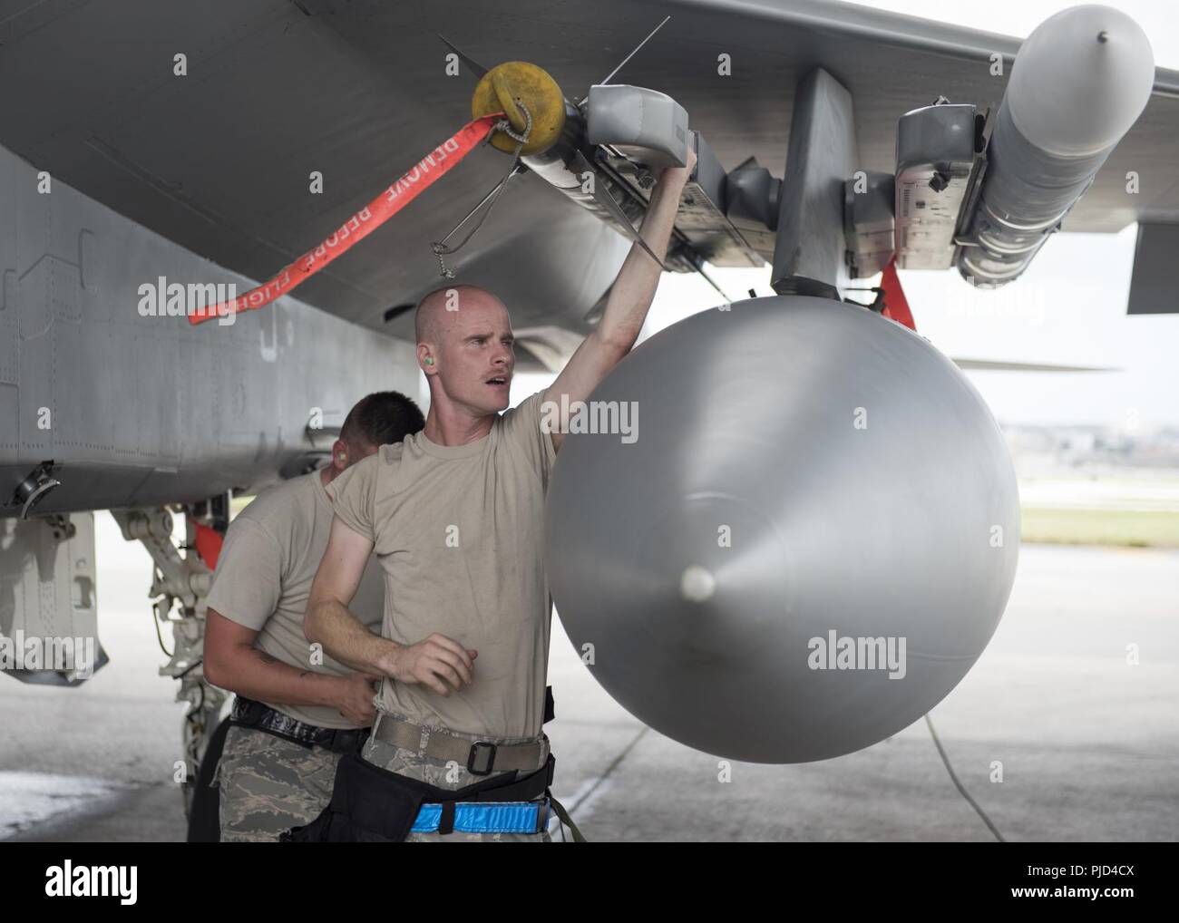 Senior Airman Christopher Leslie, 44th Aircraft Maintenance Unit weapons load crew member, loads an AIM-9x heat seeking missle during an annual 'turkey shoot' weapons load competition July 16, 2018, on Kadena Air Base, Japan. Airmen competed to load two AIM-120 advanced medium-range air-to-air missiles and one AIM-9X heat seeking missile as fast as possible. Stock Photo