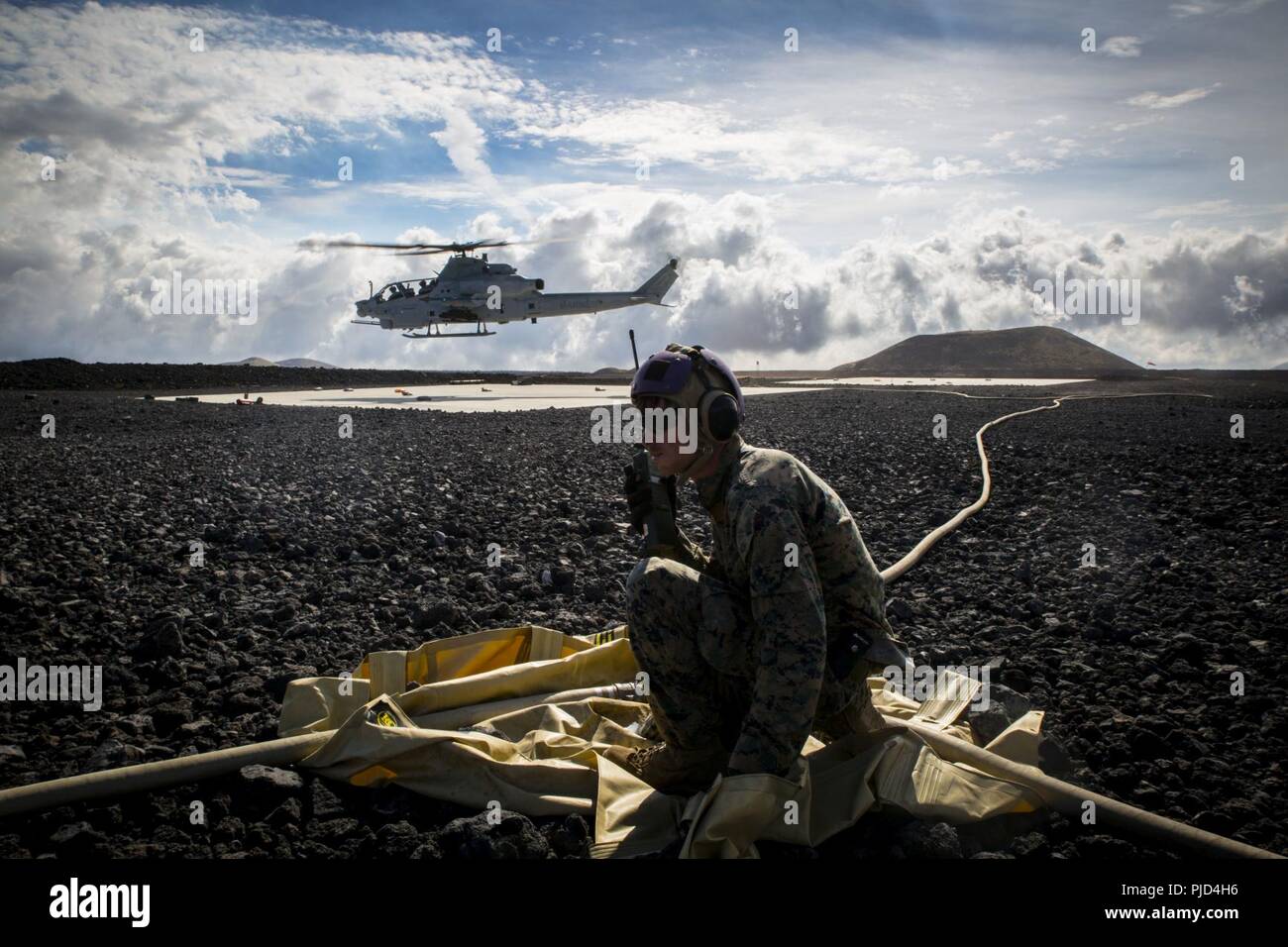 POHAKULOA TRAINING AREA, Hawaii (July 18, 2018) U.S. Marine Cpl. Michael Michehl, a line noncommissioned officer with Marine Wing Support Detachment 24, controls forward arming and refueling point operations after refueling a Bell AH-1W Super Cobra during a field test for the Expeditionary Mobile Fuel Additization Capability system as part of Rim of the Pacific (RIMPAC) exercise at Pohakuloa Training Area, Hawaii, July 18, 2018. RIMPAC provides high-value training for task-organized, highly capable Marine Air-Ground Task Force and enhances the critical crisis response capability of U.S. Marine Stock Photo