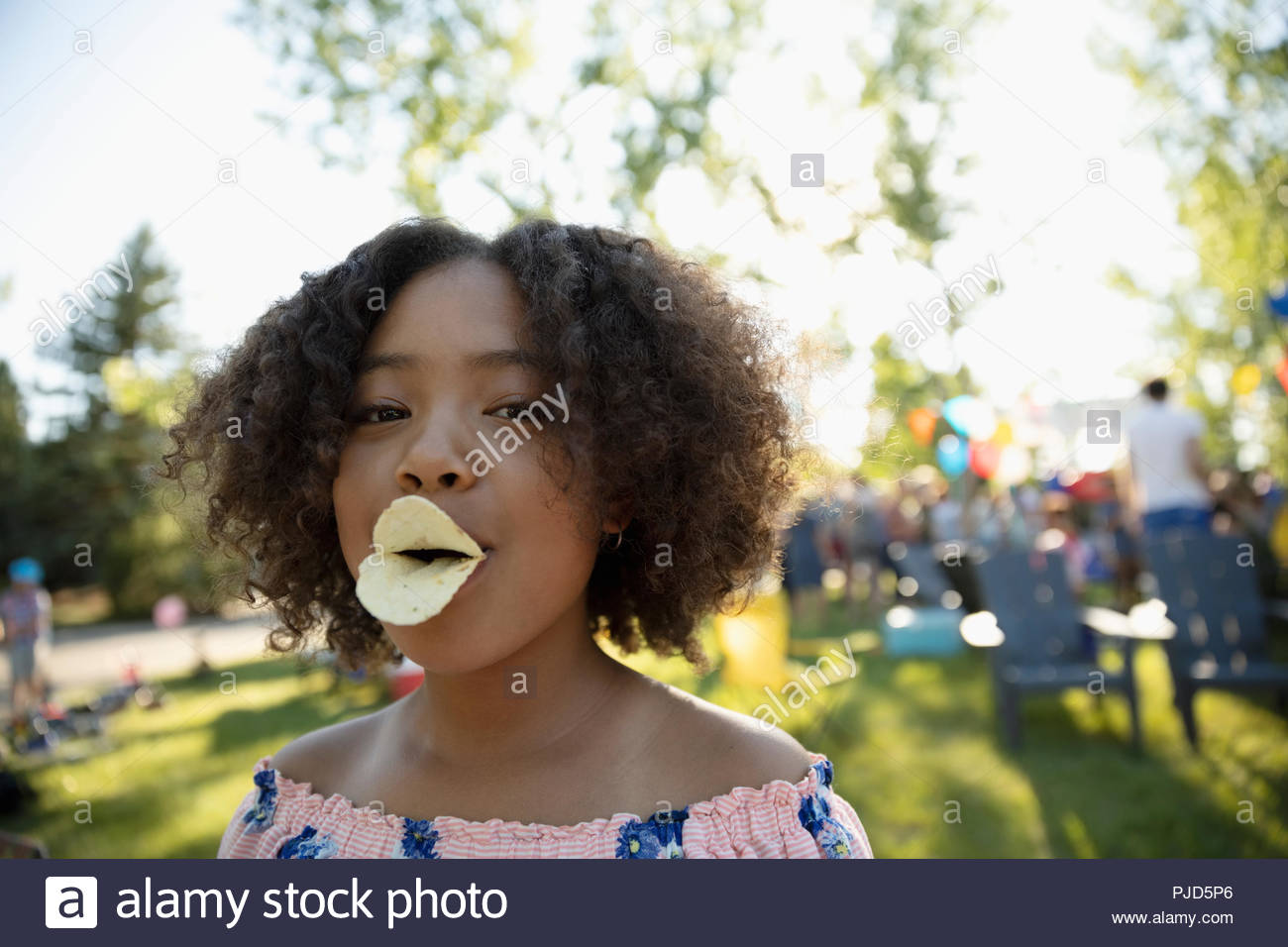 portrait-playful-girl-with-potato-chip-duck-lips-in-park-PJD5P6.jpg