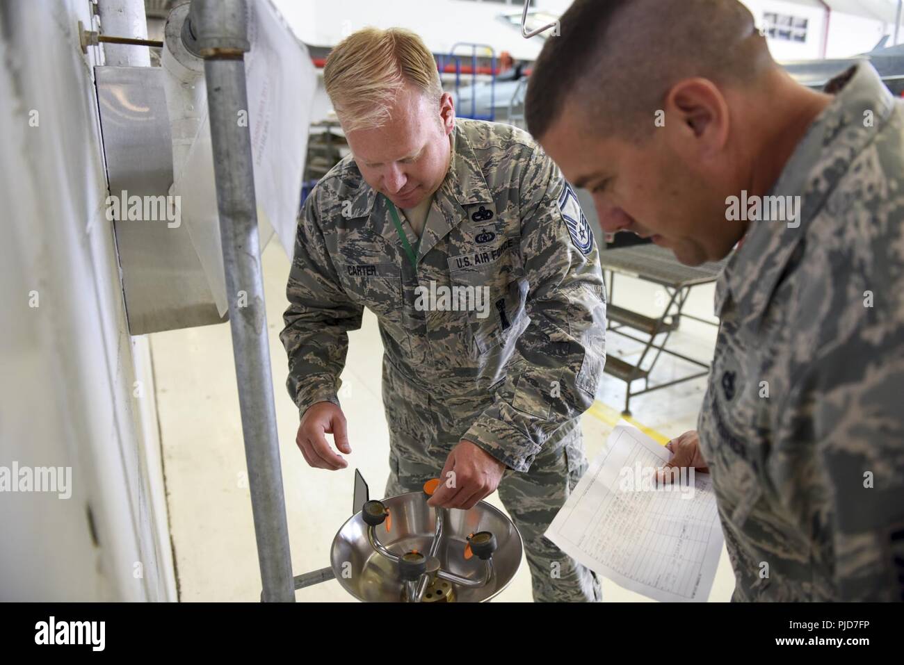 Master Sgt. Joseph Carter, occupational health and safety superintendent at the 180th Fighter Wing in Swanton, Ohio, inspects an eye wash station July 15, 2018. Carter received the 2017 Air National Guard Outstanding Individual Occupational Safety Award for superior performance and contributions to the Air Force. Stock Photo