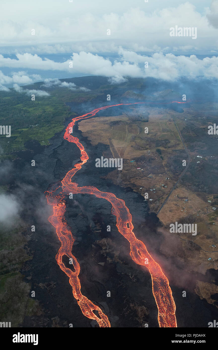 river of hot lava flows from fissure 8 in Kilauea Volcano east rift zone in Leilani Estates subdivision, near Pahoa, toward the sea at Kapoho, Hawaii Stock Photo