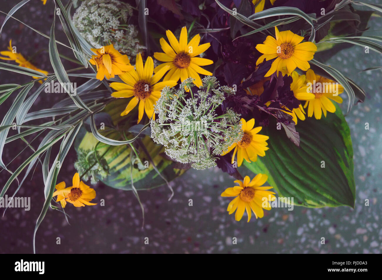 bouquet of wild flowers on amid the marble floor in the interior. tinted instagram photos Stock Photo